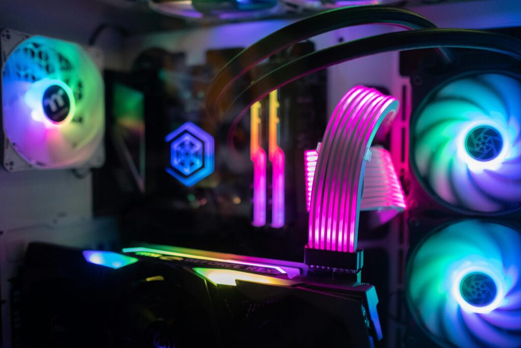 Close-up of glowing RGB components inside a custom gaming PC tower featuring cooling fans and vivid lights.