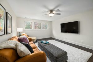 Spacious modern living room featuring a stylish sofa, TV, and cozy decor.