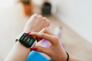 A woman interacts with a smartwatch, checking fitness data, indoors.